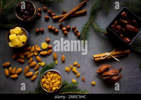 Ingrédients pour gâteau de Noël traditionnel - noix, fruits secs, dattes, cannelle. Arrière-plan de la boulangerie de Noël. Pose à plat. Copier l'espace. Banque D'Images