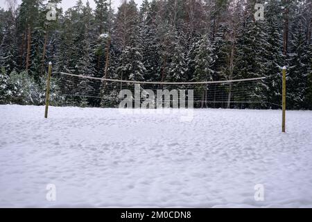 Terrain de volley-ball de plage couvert de neige avec filet. Dans une forêt enneigée Banque D'Images