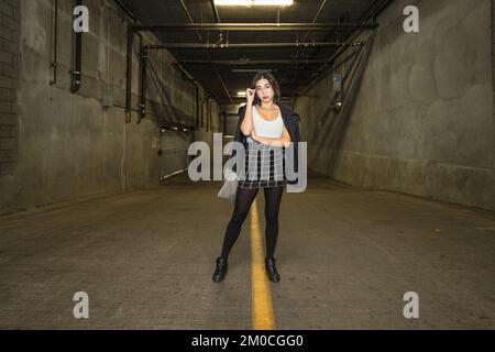 Jeune femme d'affaires debout dans un garage de stationnement Banque D'Images