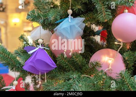 Poupées Angel en ensembles multicolores sur l'arbre de Noël. Banque D'Images