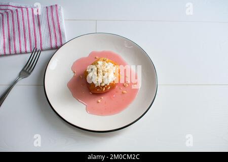 Dessert traditionnel turc de coing, le coing est cuit dans l'eau avec du sucre et servi avec de la crème et de la noisette. Banque D'Images