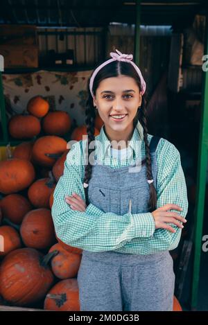 Une femme agricole vend la récolte de citrouille d'automne sur le marché Banque D'Images