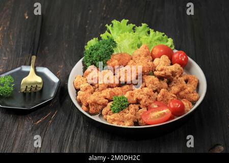 Maïs soufflé au poulet, petites tranches de poulet enrobées de miettes et de friture. Mini-poulet frit Banque D'Images