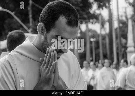 Salvador, Bahia, Brésil - 25 mai 2016 : un jeune prêtre prie pendant la procession du Corpus Christ à Salvador, Bahia. Banque D'Images