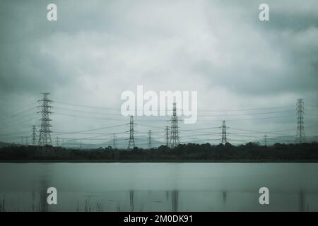 Pylônes électriques et fils électriques dans des tours brumeuses le matin ou haute tension sur beau ciel d'hiver. Borne haute tension sur ciel nuageux Banque D'Images