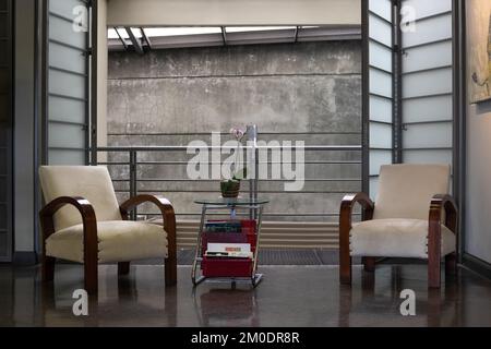 Séjour avec deux chaises en bois en cuir blanc et balcon. Banque D'Images