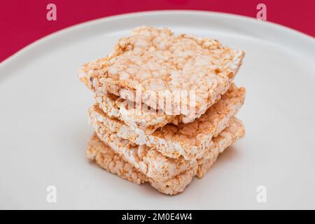 Une pile de gâteaux de riz carrés sur la plaque blanche. Pain croustillant diététique Banque D'Images