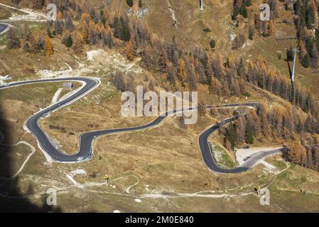 Route étroite en serpentin en asphalte dans le soleil d'automne dans les Dolomites italiens Banque D'Images