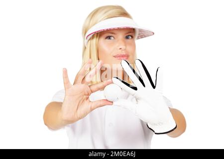 Mon ballon de chance ne me laisse jamais tomber. Studio portrait d'une jeune golfeuse femelle tenant une balle de golf isolée sur blanc. Banque D'Images