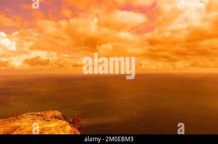 Vue aérienne coucher de soleil rouge sur la mer avec falaise volcanique rocheuse. Résumé nature été coucher de soleil océan mer fond. Petites vagues sur doré chaud Banque D'Images