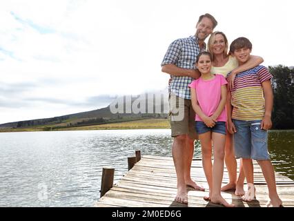 Une journée au lac. une famille aimante debout sur un quai sur un lac à la campagne. Banque D'Images