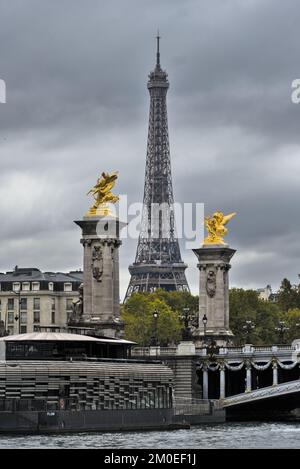 Tour Eiffel avec les statues dorées du pont Alexandre III à Paris par une journée nuageux. Banque D'Images