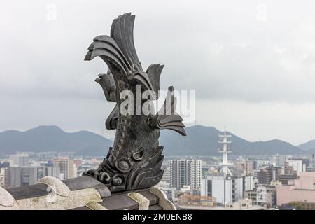 Himeji, Japon. Un poisson mythique à tête de tigre appelé shachi sur le toit de l'Egret blanc ou du château de Heron, un complexe de châteaux de l'Azuchi Momoyama Banque D'Images