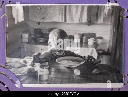 URSS - vers 1960s: Un petit garçon mange de la soupe dans un grand bol. Concept ancien album photo. Banque D'Images