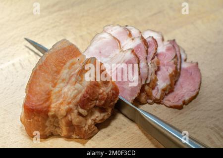 Tranches de bacon fumé sur une planche de bois. Banque D'Images