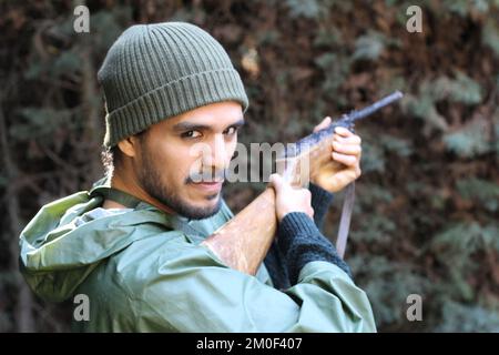 Chasseur ethnique avec des vêtements de camouflage vert Banque D'Images