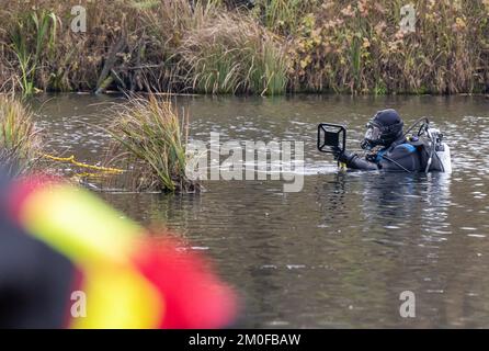 Manching, Allemagne. 06th décembre 2022. Les plongeurs policiers utilisent des détecteurs de métaux pour fouiller le lac Pichler Weiher près du musée celtique après le vol d'or. Lors d'une pause au Musée romain celtique de Manching, en haute-Bavière, un Trésor d'or pesant plusieurs kilos et composé principalement de pièces de monnaie avait été volé. Credit: Peter Kneffel/dpa/Alay Live News Banque D'Images