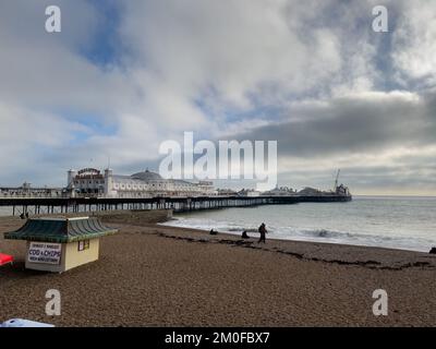 Brighton, Royaume-Uni - 12 novembre 2022 : ciel nuageux au-dessus de la plage de Brighton avec la jetée du palais de Brighton en arrière-plan. Banque D'Images