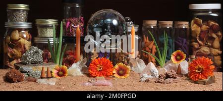 Boule de cristal avec bougies et pierres de chakra sur autel de méditation de sable rouge australien Banque D'Images