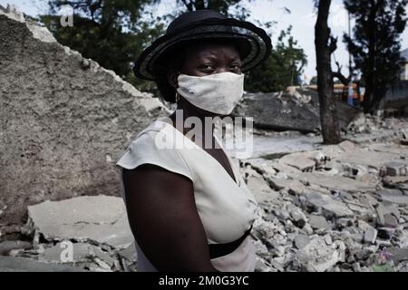 La ville de Leogane est située très près de l'épicentre du tremblement de terre à Haïti et 80 pour cent de la ville se trouve en ruines. Des milliers de réfugiés tentent de s'échapper des destructions. Dans la rue principale de Leogane, la plupart des bâtiments sont en ruines. L'apathie est omniprésente et seules des tentatives sporadiques sont faites pour creuser dans les ruines. Banque D'Images