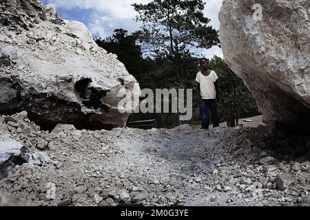 La ville de Leogane est située très près de l'épicentre du tremblement de terre à Haïti et 80 pour cent de la ville se trouve en ruines. Des milliers de réfugiés tentent de s'échapper des destructions. Dans la rue principale de Leogane, la plupart des bâtiments sont en ruines. L'apathie est omniprésente et seules des tentatives sporadiques sont faites pour creuser dans les ruines. Banque D'Images