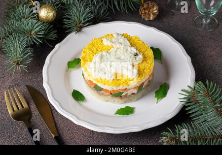 Salade feuilletée Mimosa pour le nouvel an avec thon en conserve, pommes de terre et carottes, lapin décoré d'œufs Banque D'Images