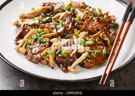 Steak de bœuf poêlé avec champignons asiatiques près de l'assiette sur la table. Horizontale Banque D'Images