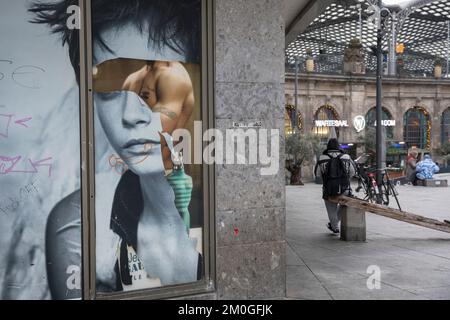 Graffiti sexiste sur une affiche publicitaire partiellement déchirée à la gare centrale de Cologne, Allemagne. Sexistisches graffitis auf einem teils abgerissenen W. Banque D'Images