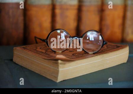 Lunettes de lecture démodées reposant sur un livre - John Gollop Banque D'Images