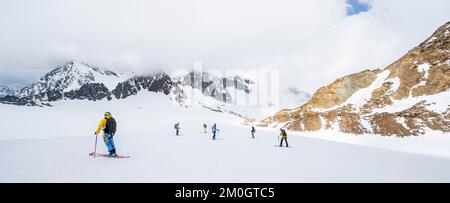 Groupe de skieurs et de planchistes en descente à Alpeiner Ferner, Alpes de Stubai, Tyrol, Autriche, Europe Banque D'Images