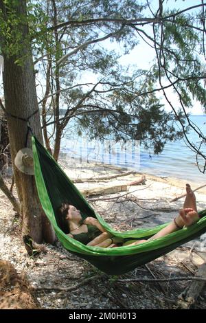 Jeune femme se détendant dans un hamac sur une plage en Virginie, aux États-Unis Banque D'Images