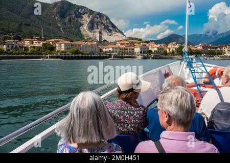 Italie le tourisme des lacs, vue arrière en été des passagers matures à bord d'un ferry sur le lac Maggiore à l'approche de la ville de Baveno, Piémont, Italie Banque D'Images