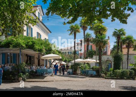 Îles Borromeo Italie, vue en été d'une rue bordée de cafés dans le pittoresque village de pêcheurs d'Isola dei Pescatori, Lac majeur, Piémont, Italie Banque D'Images