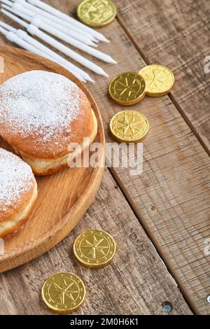 Bonne Hanoukkah. Beignets sucrés Hanukkah, boîtes-cadeaux, bougies blanches et pièces de chocolat sur fond de bois ancien. Image et concept de vacances juives Banque D'Images