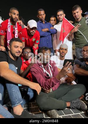 Les fans de football regardant le match Maroc / Espagne à l'extérieur du stade Education City, au Qatar, lors de la coupe du monde de la FIFA 2022. Il y avait des scènes tendues plus tôt à l'extérieur du stade, alors que la police anti-émeutes avait mis son casque, que la police montée et les chiens avançait et qu'au moins deux personnes ont été retirées par les forces de sécurité. Des dizaines de supporters marocains étaient à l'extérieur du stade alors que leur équipe jouait en Espagne. Date de la photo: Mardi 6 décembre 2022. Banque D'Images