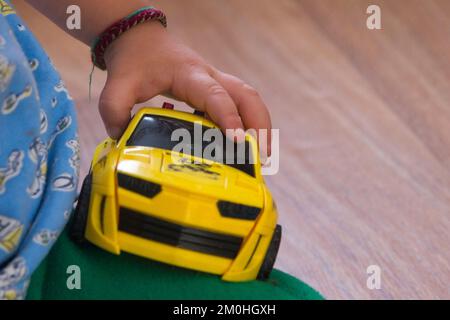 Main d'enfant tenant une voiture-jouet en gros plan Banque D'Images