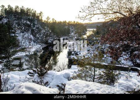 Magnifique paysage pittoresque enneigé d'angle Rock au parc national de l'Interstate à St. Croix River lors d'une soirée d'hiver à Taylors Falls, Minnesota, États-Unis. Banque D'Images