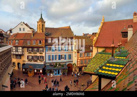 France, Haut Rhin, Colmar, maisons à pignons et maisons à ossature de bois dans la Grand rue avec décorations de Noël, à droite l'ancien douane ou édifice de contrôle des douanes (Koifhus) et la collégiale Saint-Martin en arrière-plan Banque D'Images