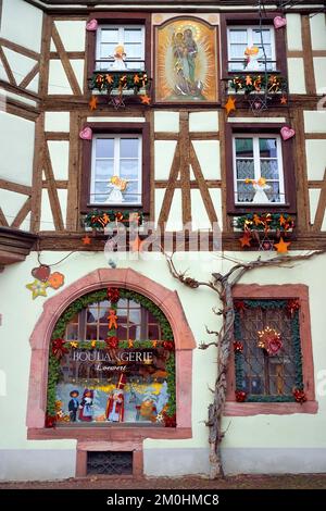 France, Haut Rhin, Strasbourg, Kaysersberg, maison à colombages de la boulangerie Loewert avec une peinture de la Vierge à l'enfant sur la façade et des décorations de Noël Banque D'Images