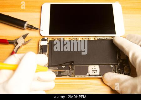 Vue de dessus d'un technicien réparant un smartphone Banque D'Images