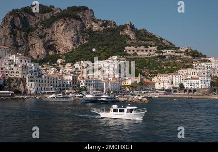 Vue générale de la ville d'Amalfi depuis la marina, en direction de la ville principale avec Battellieri Amalfi en premier plan et falaises pittoresques en arrière-plan. Banque D'Images