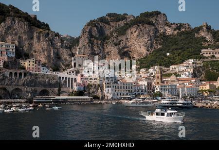 Vue générale de la ville d'Amalfi depuis la marina, en direction de la ville principale avec Battellieri Amalfi en premier plan et falaises pittoresques en arrière-plan. Banque D'Images