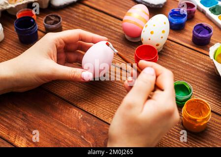 Une femme avec une pampille peint des œufs de Pâques. Préparer des décorations pour Pâques Banque D'Images