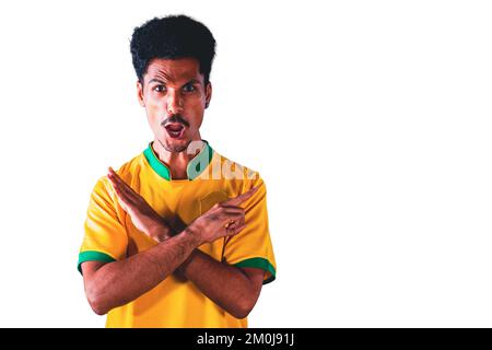 Joueur de football brésilien fêtant sur fond blanc. Portrait dramatique d'un drapeau de maintien de joueur de football noir. Banque D'Images