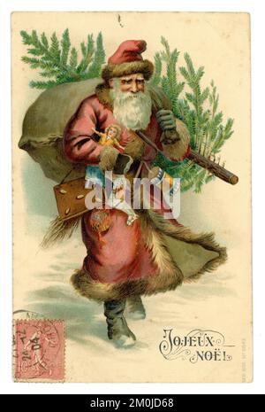 Époque édouardienne carte de voeux carte postale du Père Noël portant des cadeaux et un arbre avec timbre français sur le devant, salutations est joyeux Noël. Carte de Noël victorienne cartes. Publié / daté du 24 décembre 1904 Banque D'Images