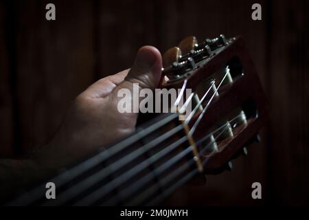 Guitariste qui écoute sa guitare et se prépare à monter sur scène Banque D'Images