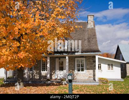 Vieux vers 1781 Maison en pierre de campagne de style Canadiana avec toit de bardeaux de cèdre en automne. Banque D'Images