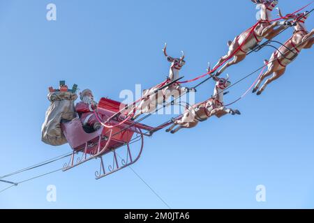 Los Angeles, CA, Etats-Unis – 5 décembre 2022 : le Père Noël et son renne volent dans un ciel bleu dans un centre commercial de Los Angeles, CA. Banque D'Images