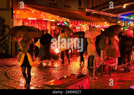 Rues pavées la nuit des pluies avec des lumières rouges à Stavanger Banque D'Images