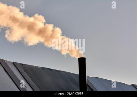 la fumée vient de la cheminée de la bourgeoisie, le poêle est chauffé. Banque D'Images